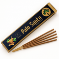 A box of Palo Santo incense with several incense sticks placed in front on a clean white background. The box is dark navy blue with gold lettering and decorative illustrations, and the incense sticks are light brown.
