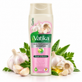 A bottle of Vatika Naturals Multivitamin Shampoo with garlic and parsley props on a white background.